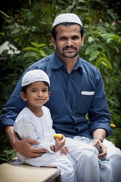 Father and young son in traditional muslim headwear